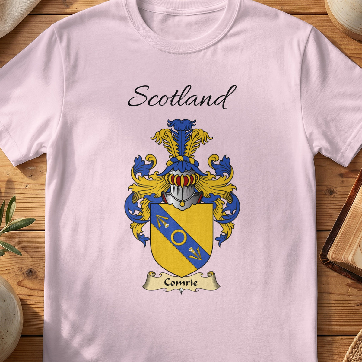 Light Pink Comrie Scottish family shield T-shirt featuring a blue diagonal band with gold detailing