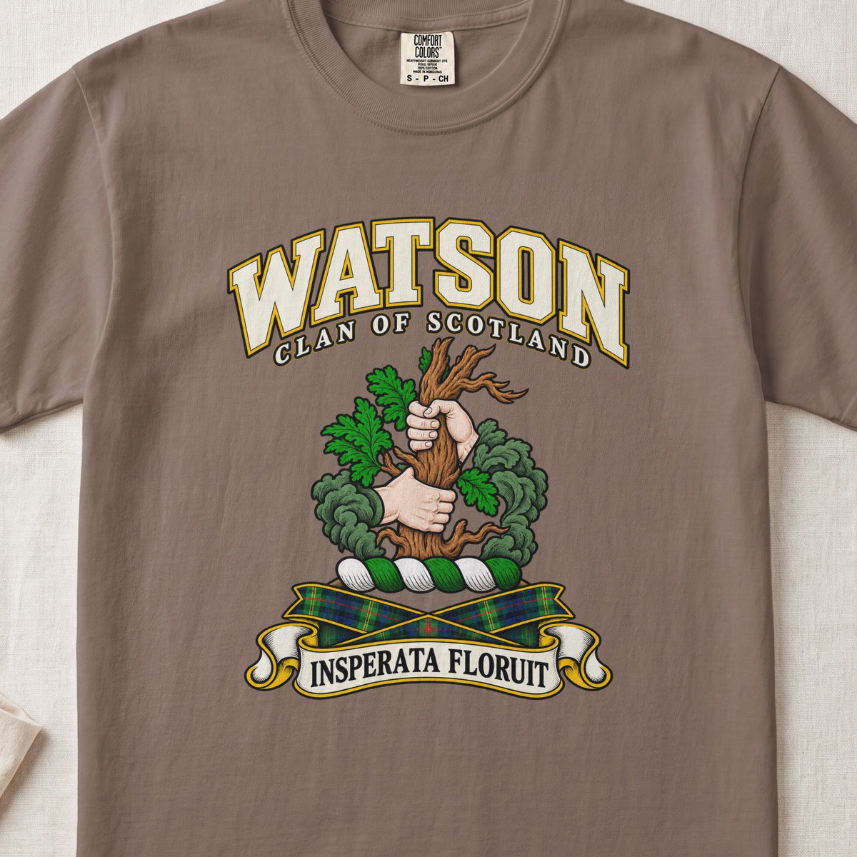 Watson Scottish clan T-shirt in Espresso, front view with two hands gripping a tree trunk with green foliage and motto banner.