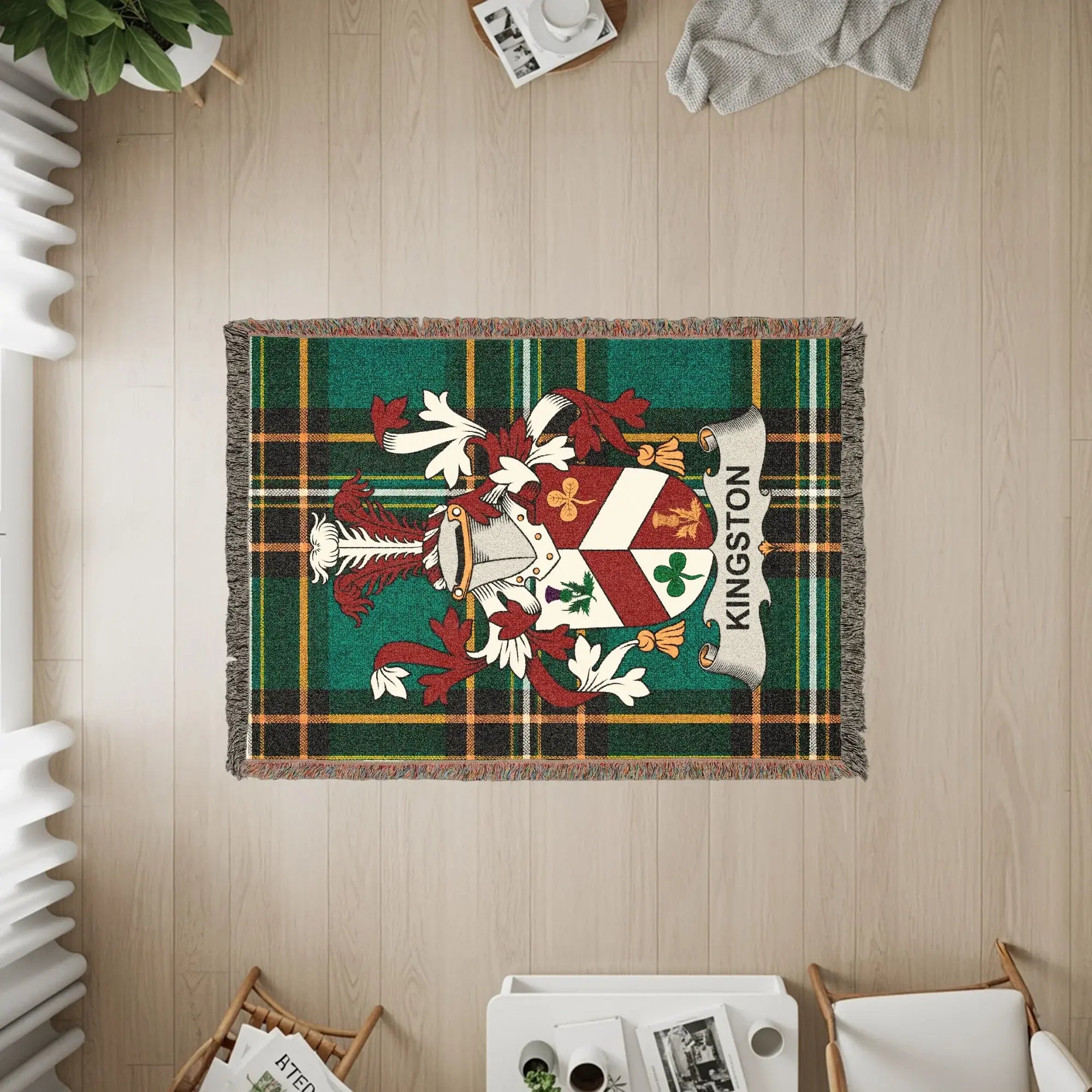 Woven blanket with Kingston crest on green plaid background.