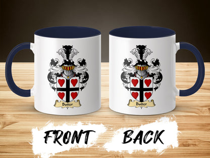 Two views of a white mug with dark blue handle, displaying a coat of arms with red hearts.