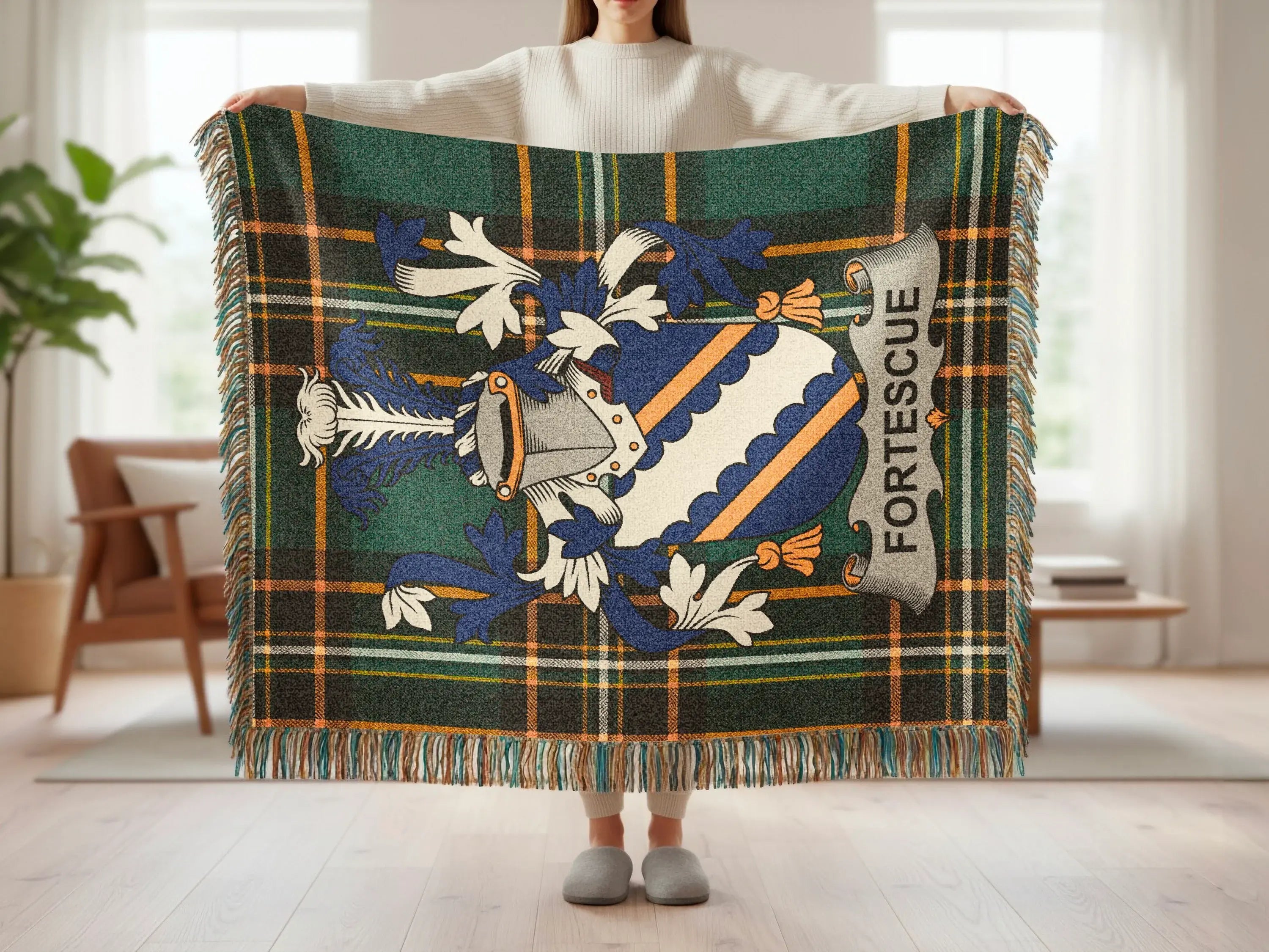 Tartan blanket with Fortescue crest and fringed edges held by a person.