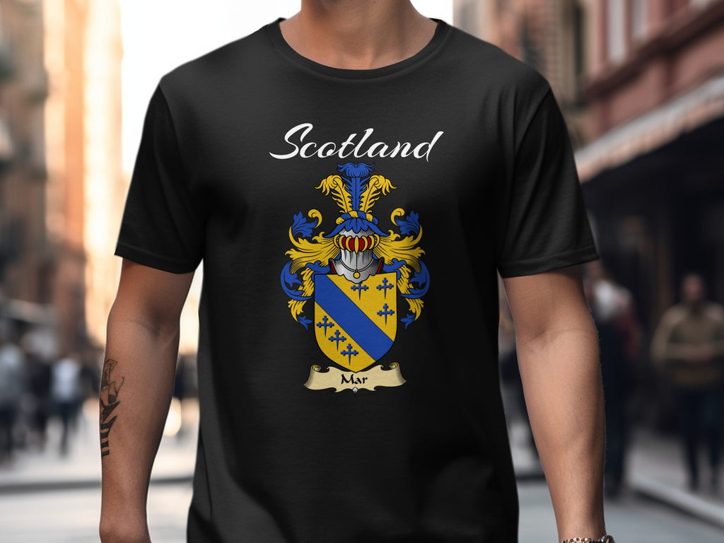 Model wearing a black Mar T-shirt featuring a gold shield crossed by a blue diagonal band