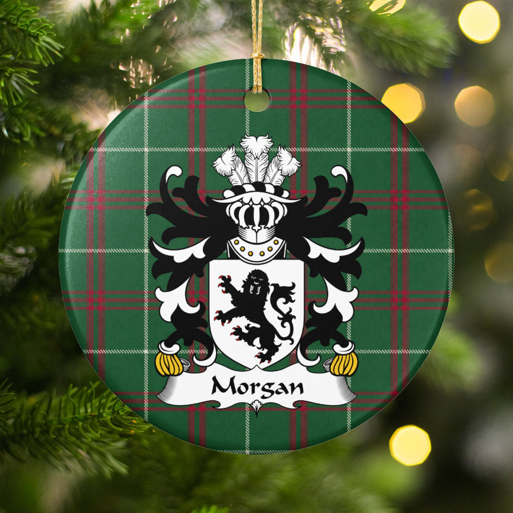 Morgan ornament, Style 2 hanging among Christmas tree branches and warm lights; a black lion on a white shield on Welsh national tartan.