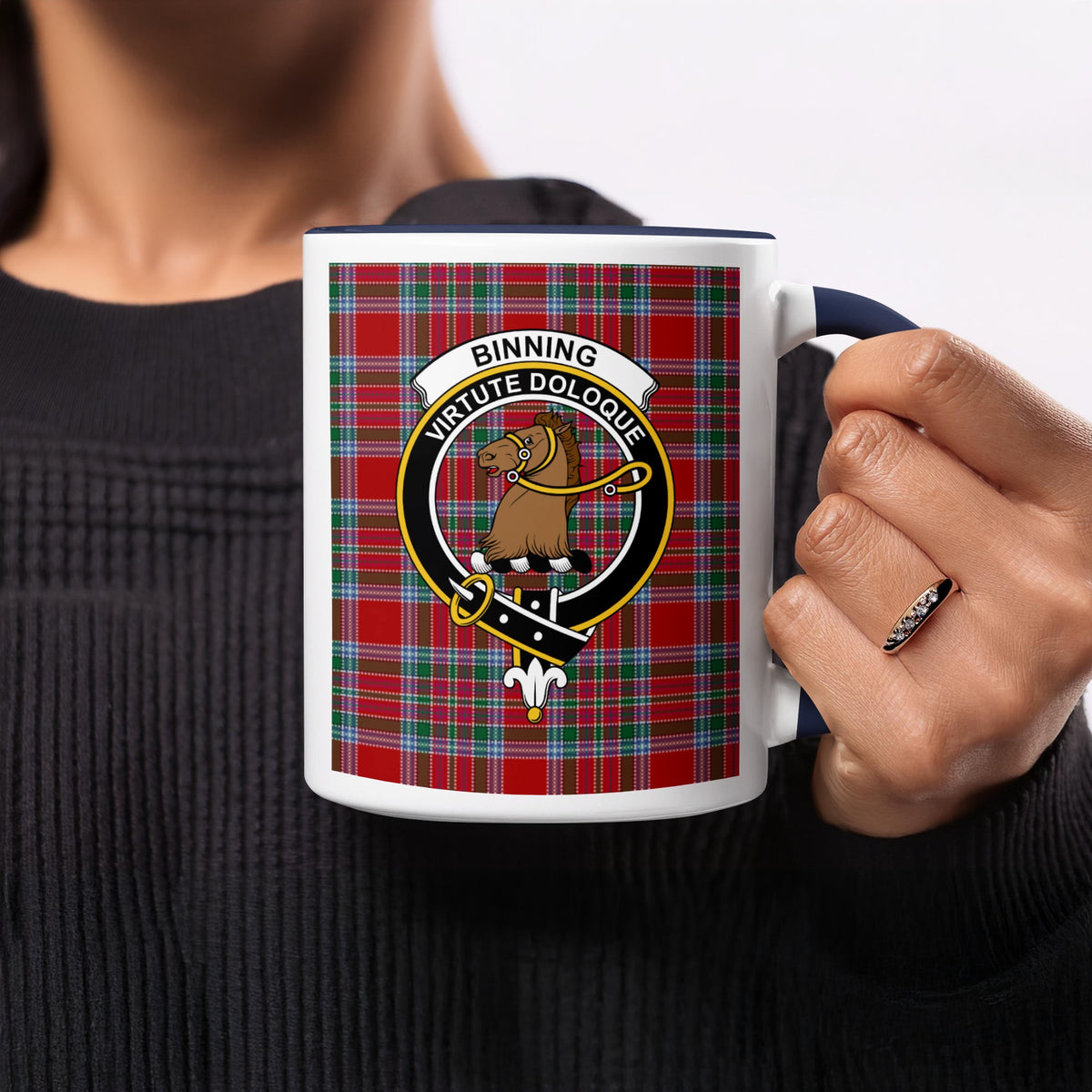 Close-up lifestyle view of Binning Scottish family crest artwork on a navy 11 oz accent mug with a tartan background