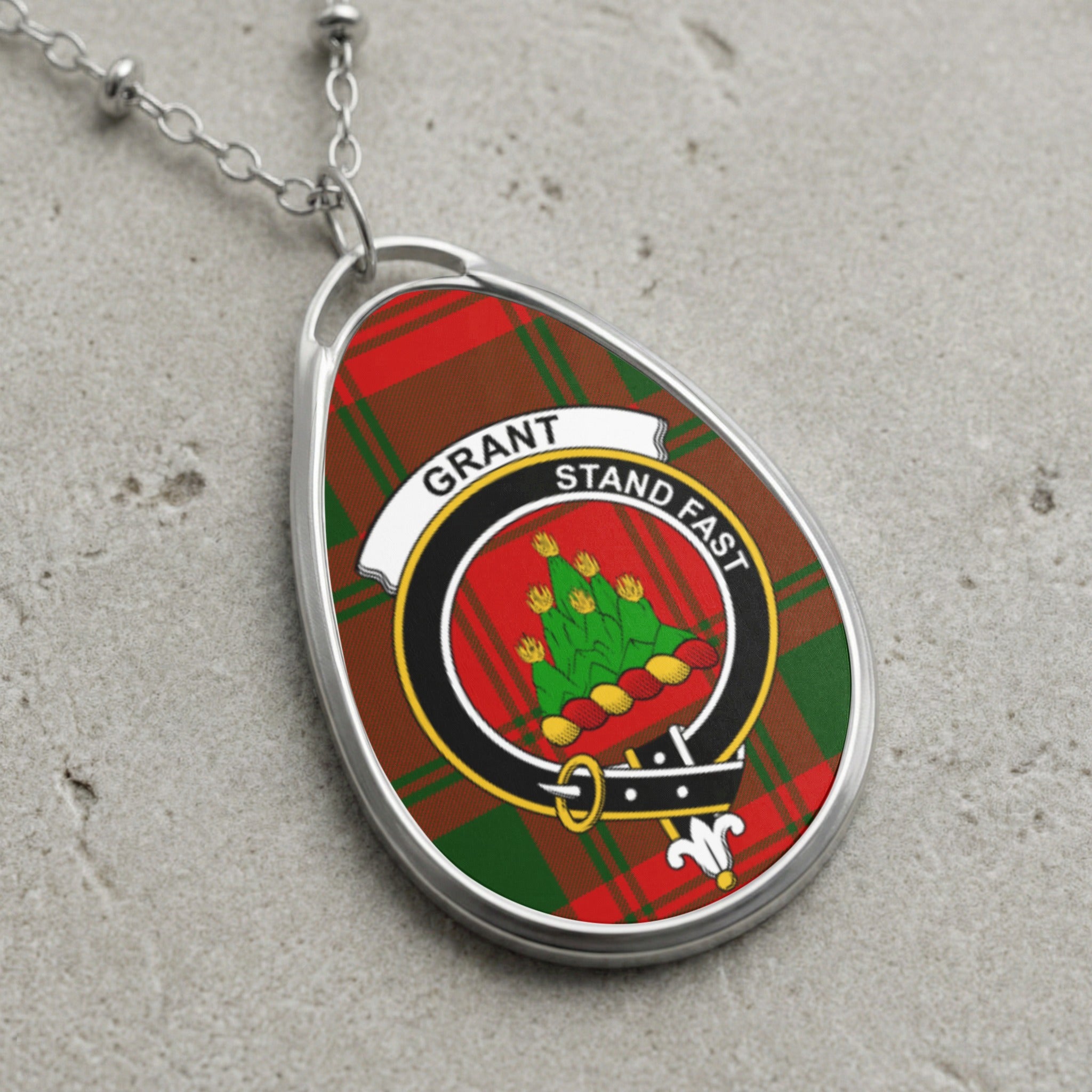 Grant clan Scottish tartan necklace with clan crest and Stand Fast motto on tartan background
