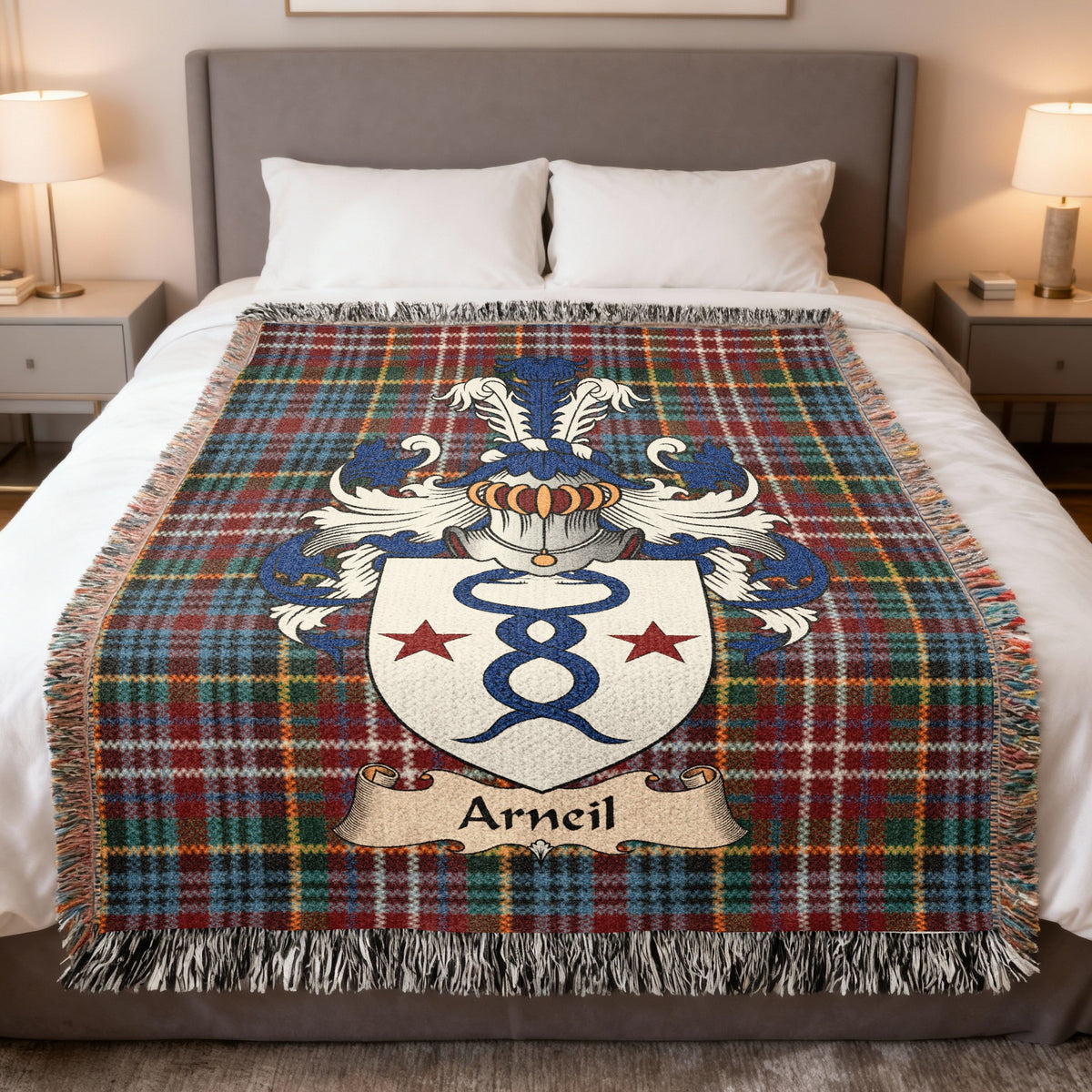 Arneil Scottish family crest woven blanket on a Caledonia tartan background, displayed on a bed