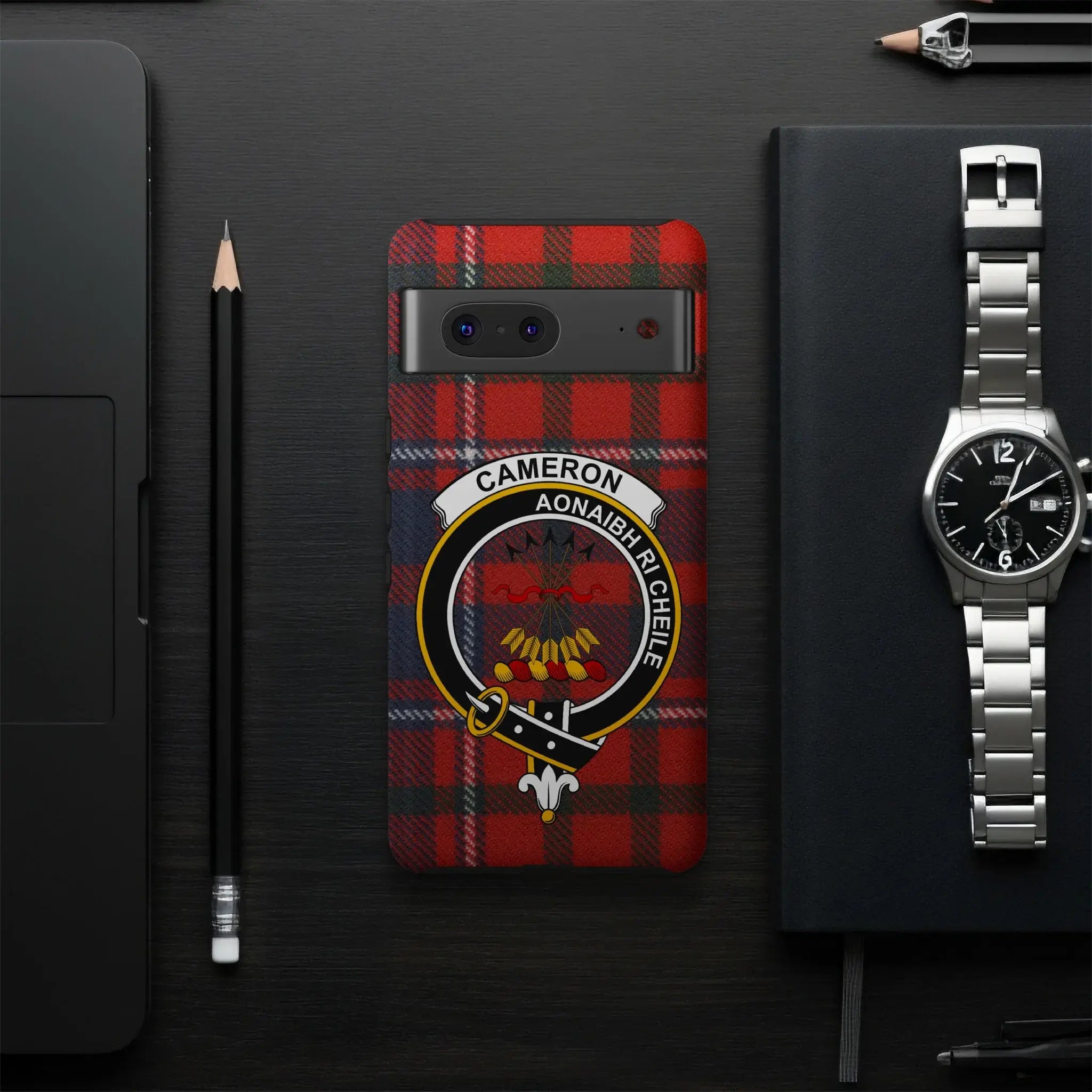 Cameron tartan phone case flat lay — full red clan crest print with Unite motto visible