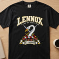 Lennox white swan crest with gold detail graphic on a black Comfort Colors T-shirt, front view