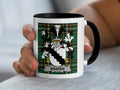 Mug with Braden family crest and black handle held by a hand.