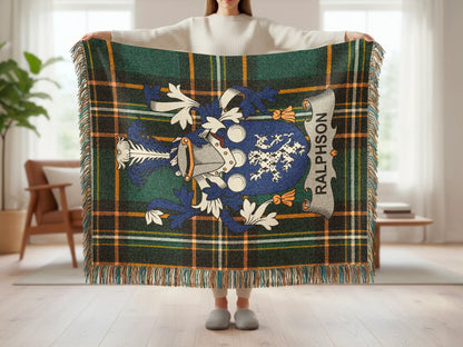 Tartan blanket with Ralposon crest and fringe held by person.