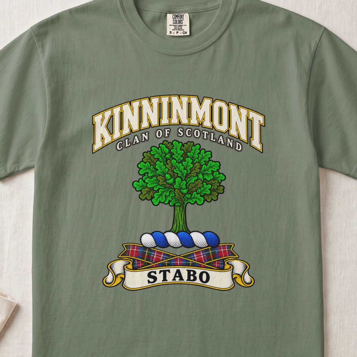 Kinninmont Scottish clan T-shirt in Moss, front view with a green tree and motto banner.