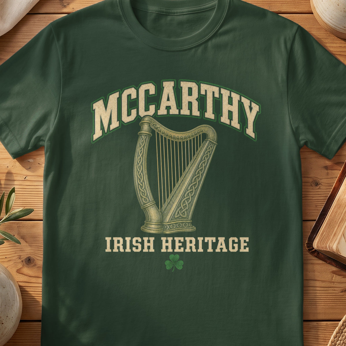 McCarthy Irish harp T-shirt in Forest Green, with cream surname lettering, a gold-toned harp, green shamrock and “Irish Heritage” text.