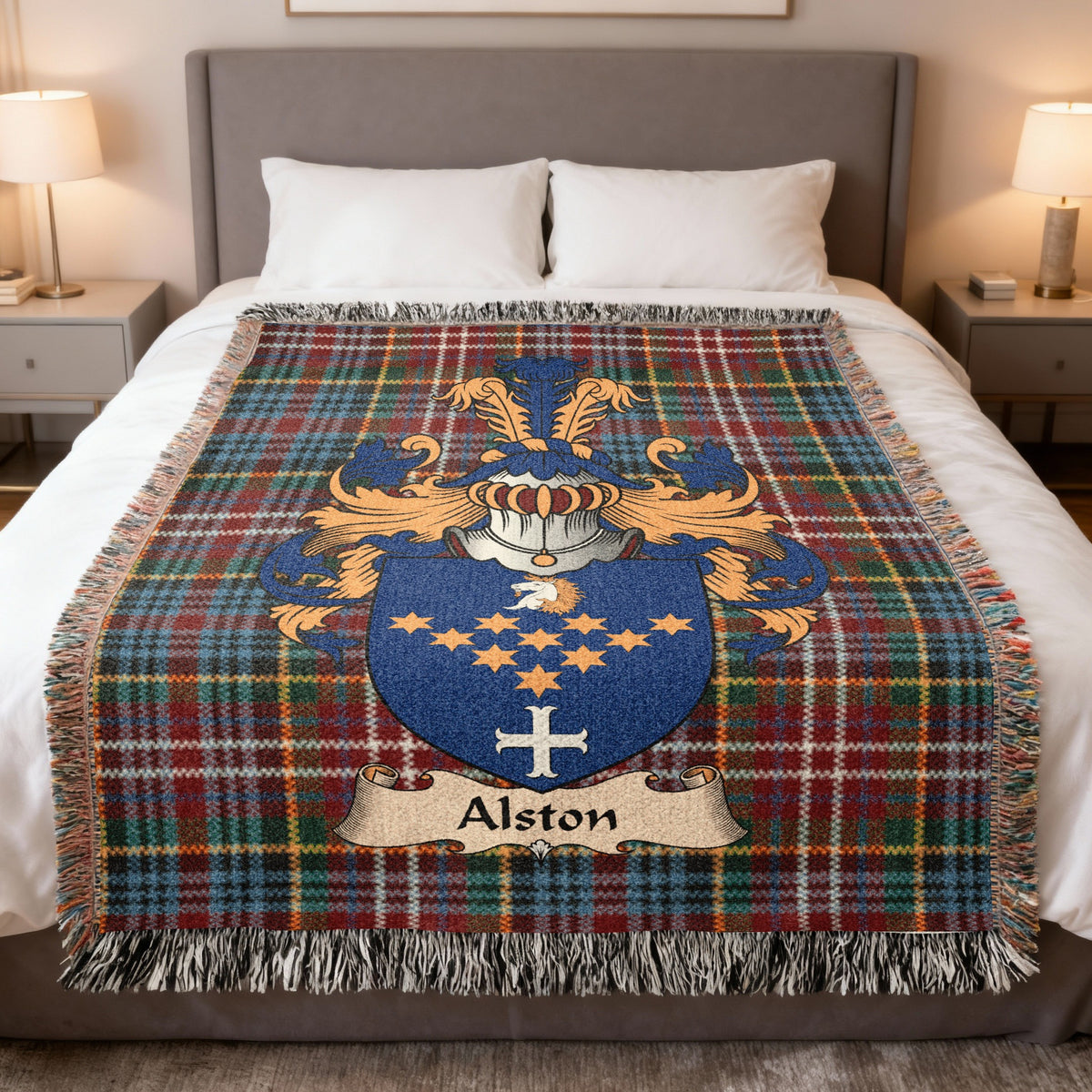 Alston Scottish family crest woven blanket on a Caledonia tartan background, displayed on a bed