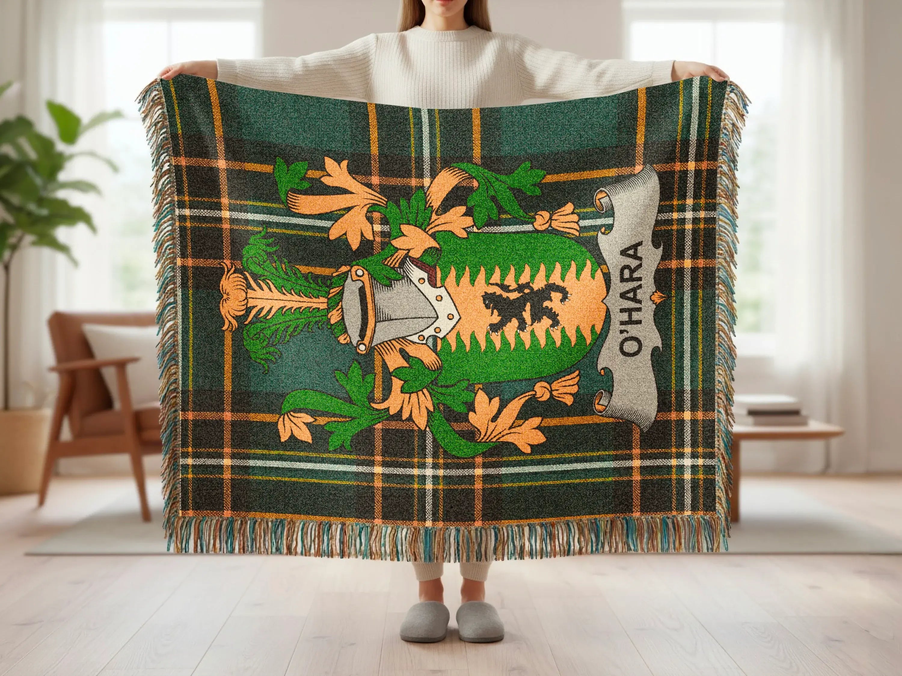 Green tartan blanket with O'Hara crest held by a person.