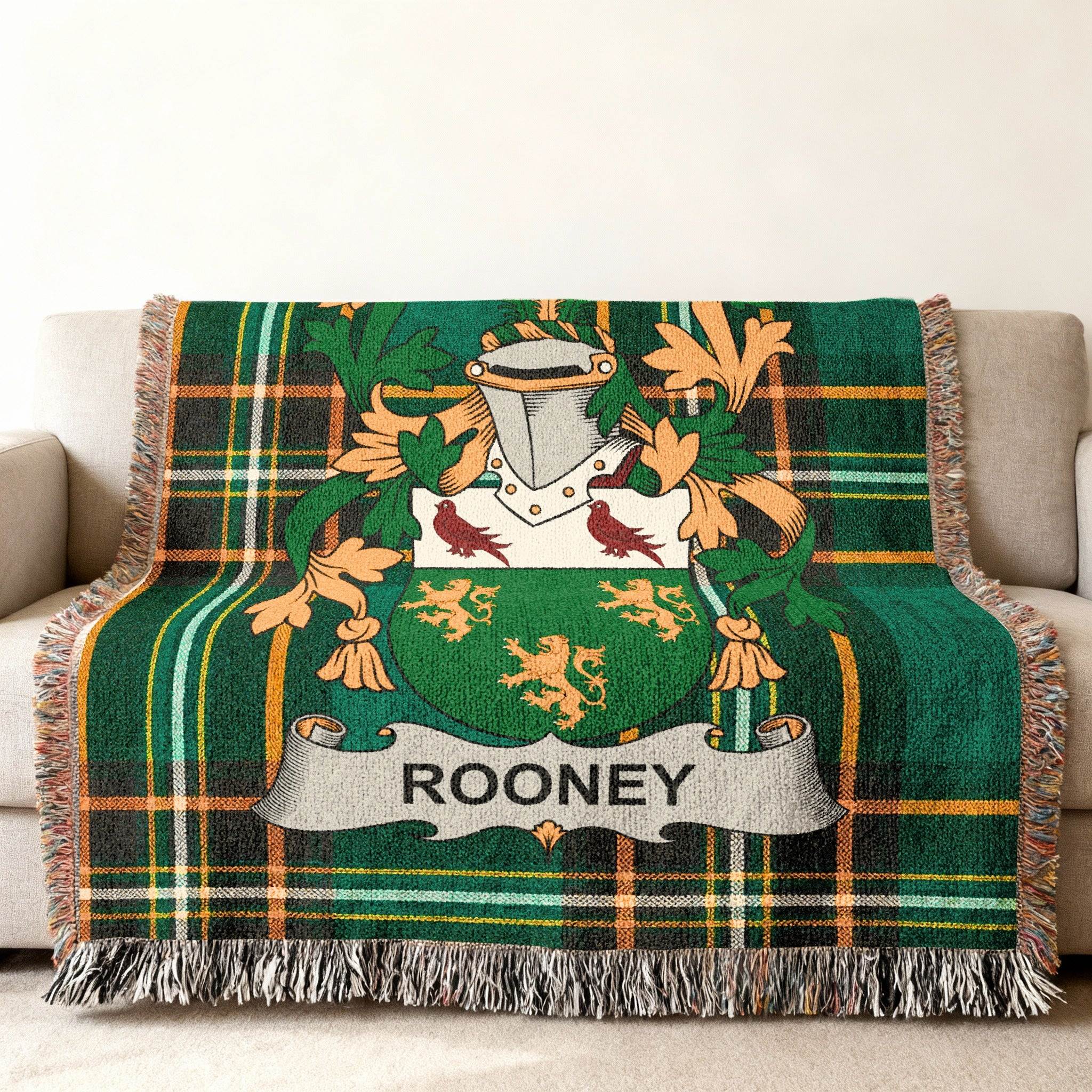 Woven blanket with Rooney family crest on green plaid background.