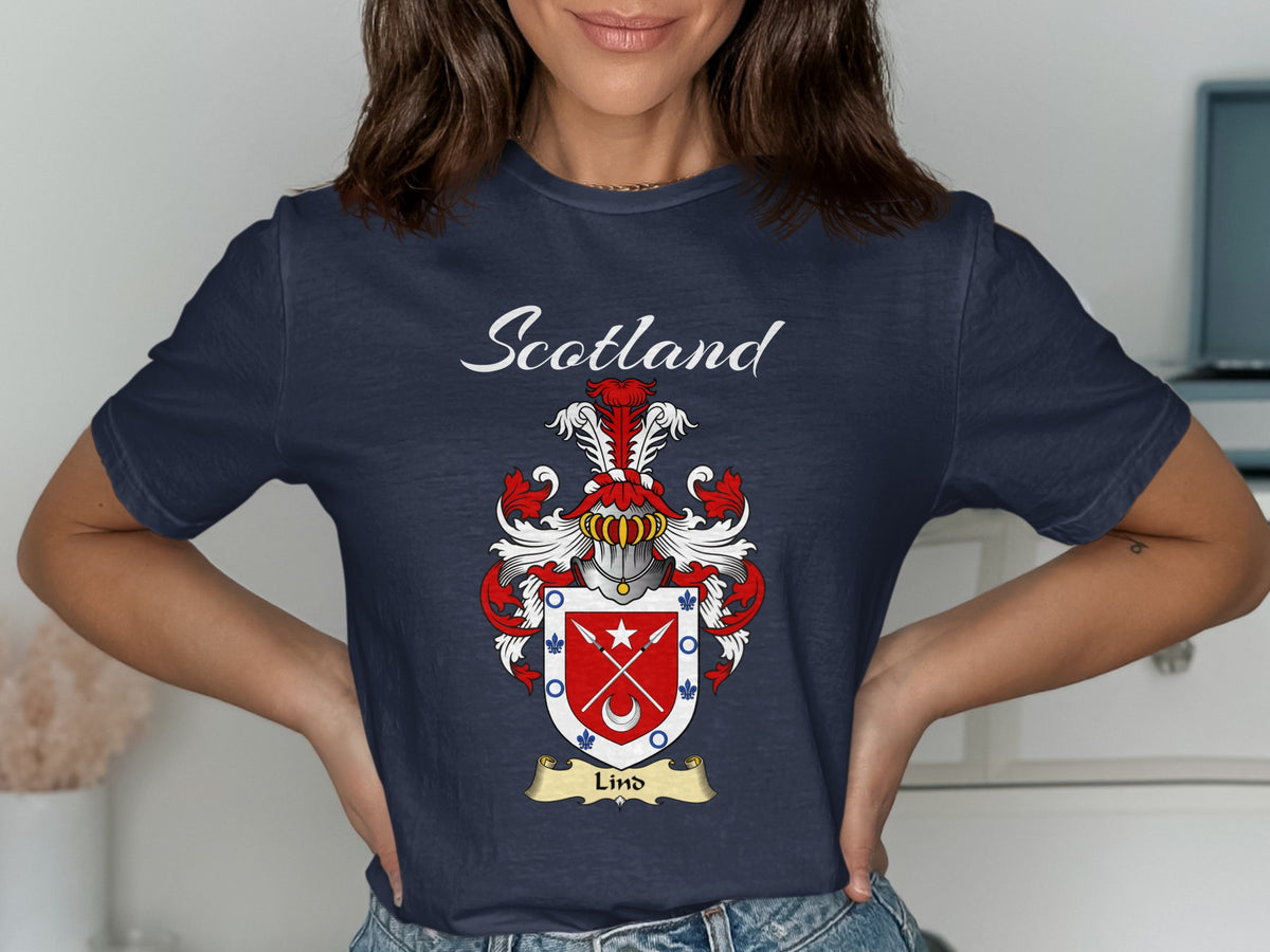 Model wearing a navy Lind T-shirt featuring crossed arrows and a crescent on a red shield