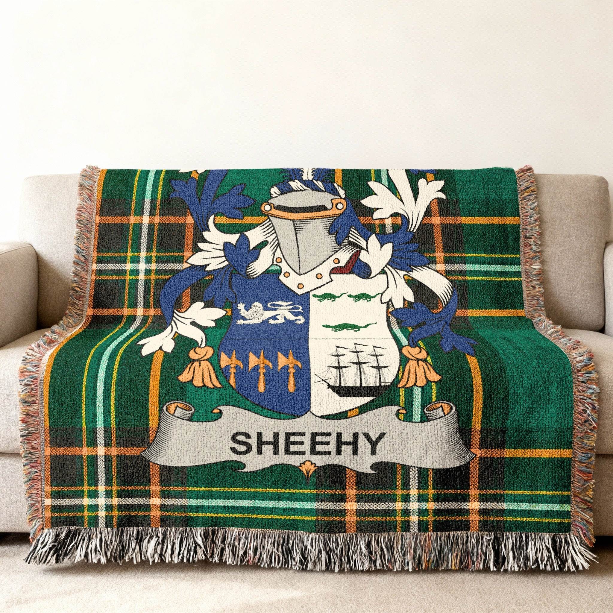Woven blanket featuring the Sheehy family crest on a green plaid background.