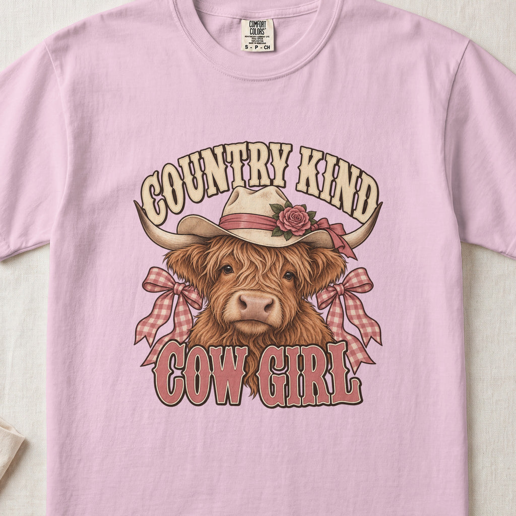 Country Kind Cow Girl Highland cow design on a Blossom Comfort Colors 1717 T-shirt, flat lay