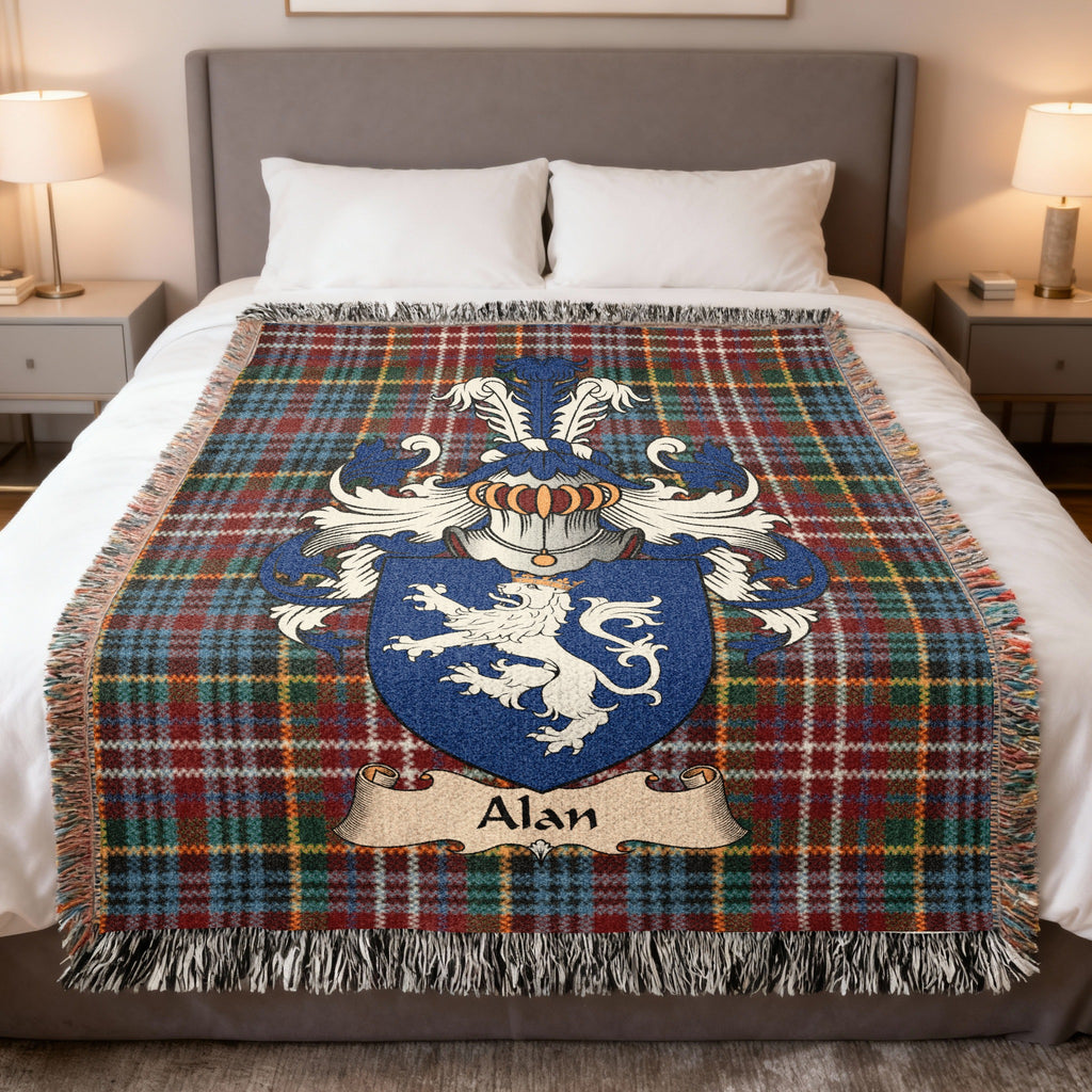 Alan Scottish family crest woven blanket on a Caledonia tartan background, displayed on a bed