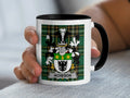 White mug with black rim and handle, featuring a green plaid coat of arms with "ACHESON" text.