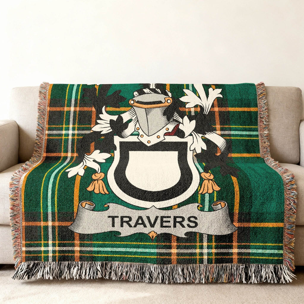 Tartan throw blanket with Travers family crest on a couch.
