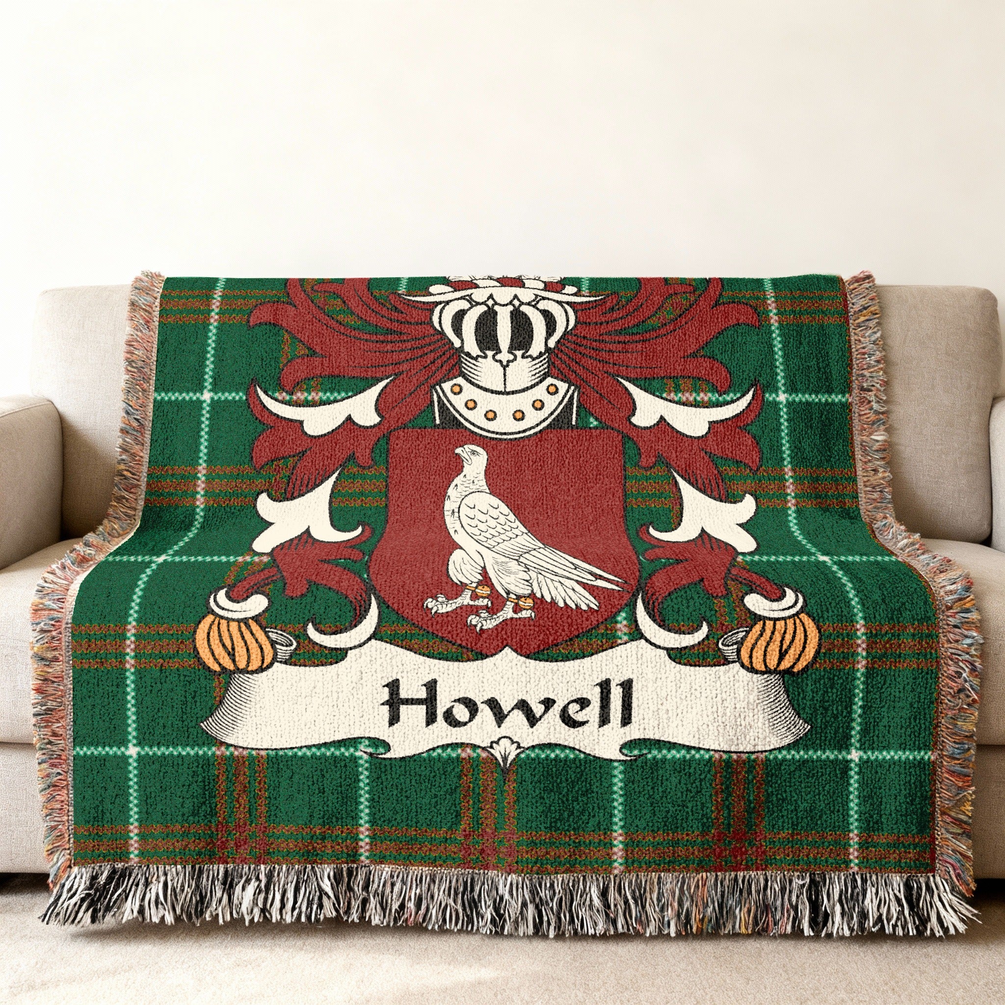 Green plaid throw blanket featuring the Howell family crest with a bird.