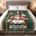Tartan blanket with the Franklin family crest on a bed.