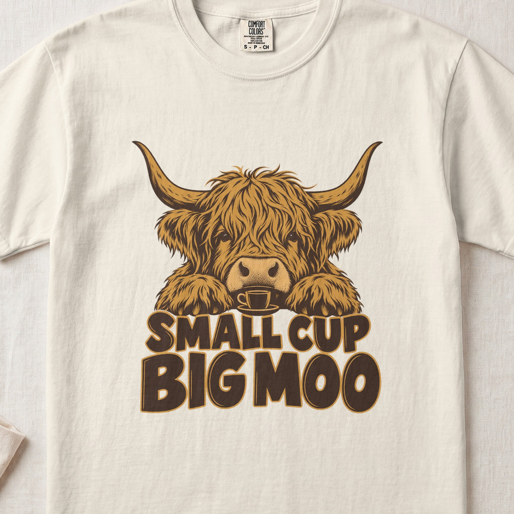 Small Cup, Big Moo Highland cow design on an Ivory Comfort Colors 1717 T-shirt, flat lay