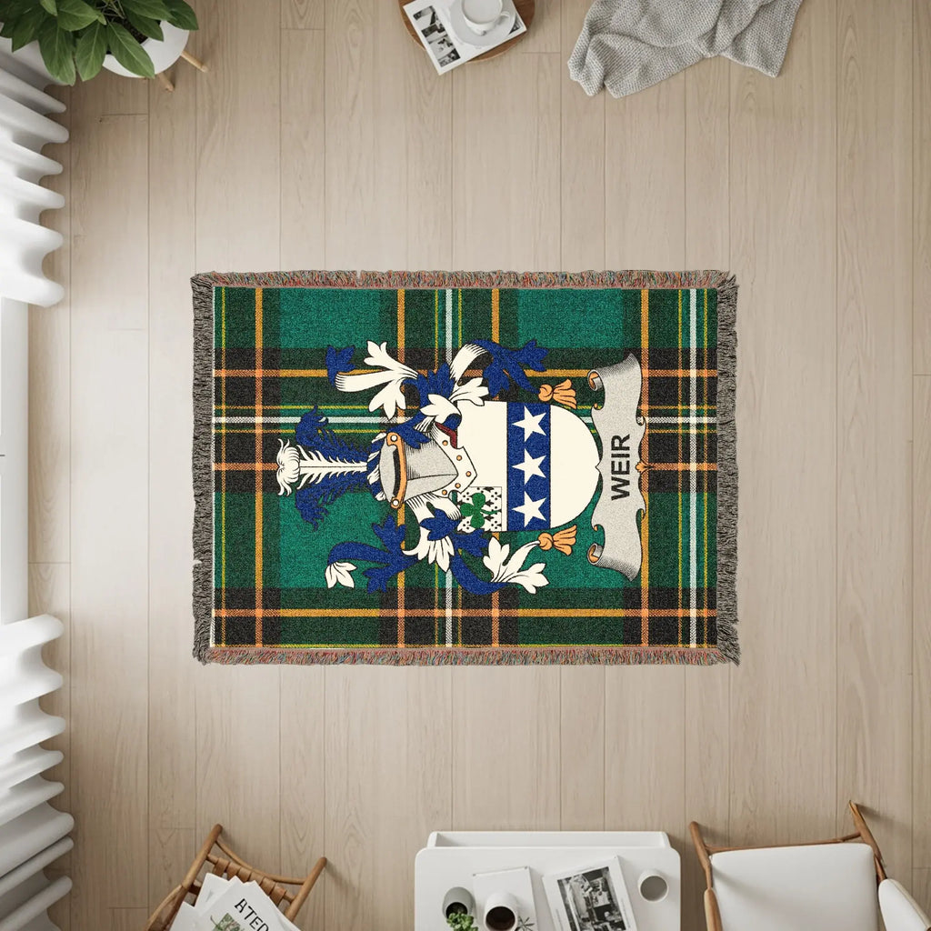 Weir family crest woven blanket with green plaid background and fringe.
