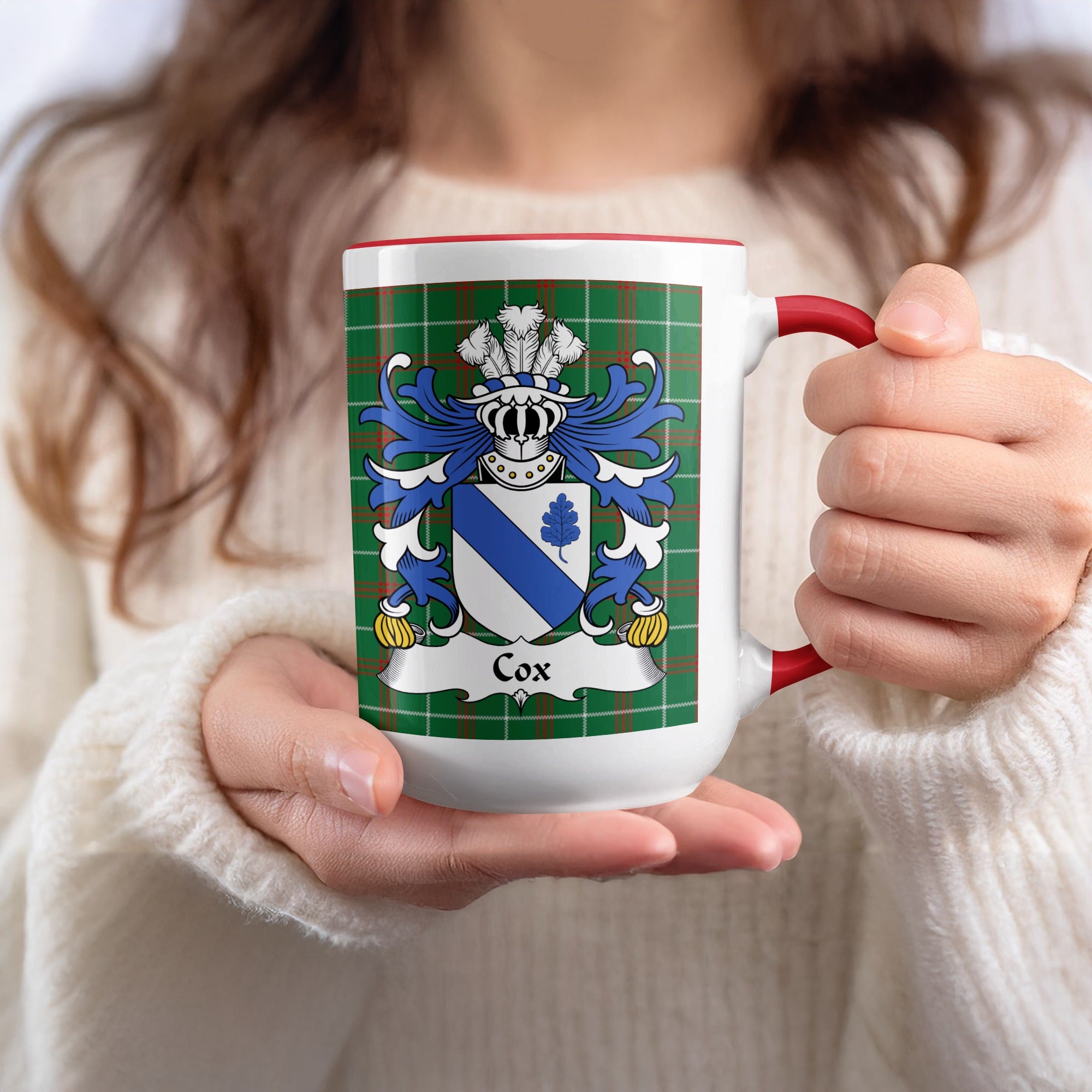 White mug with red handle featuring a plaid pattern and the Cox family crest.