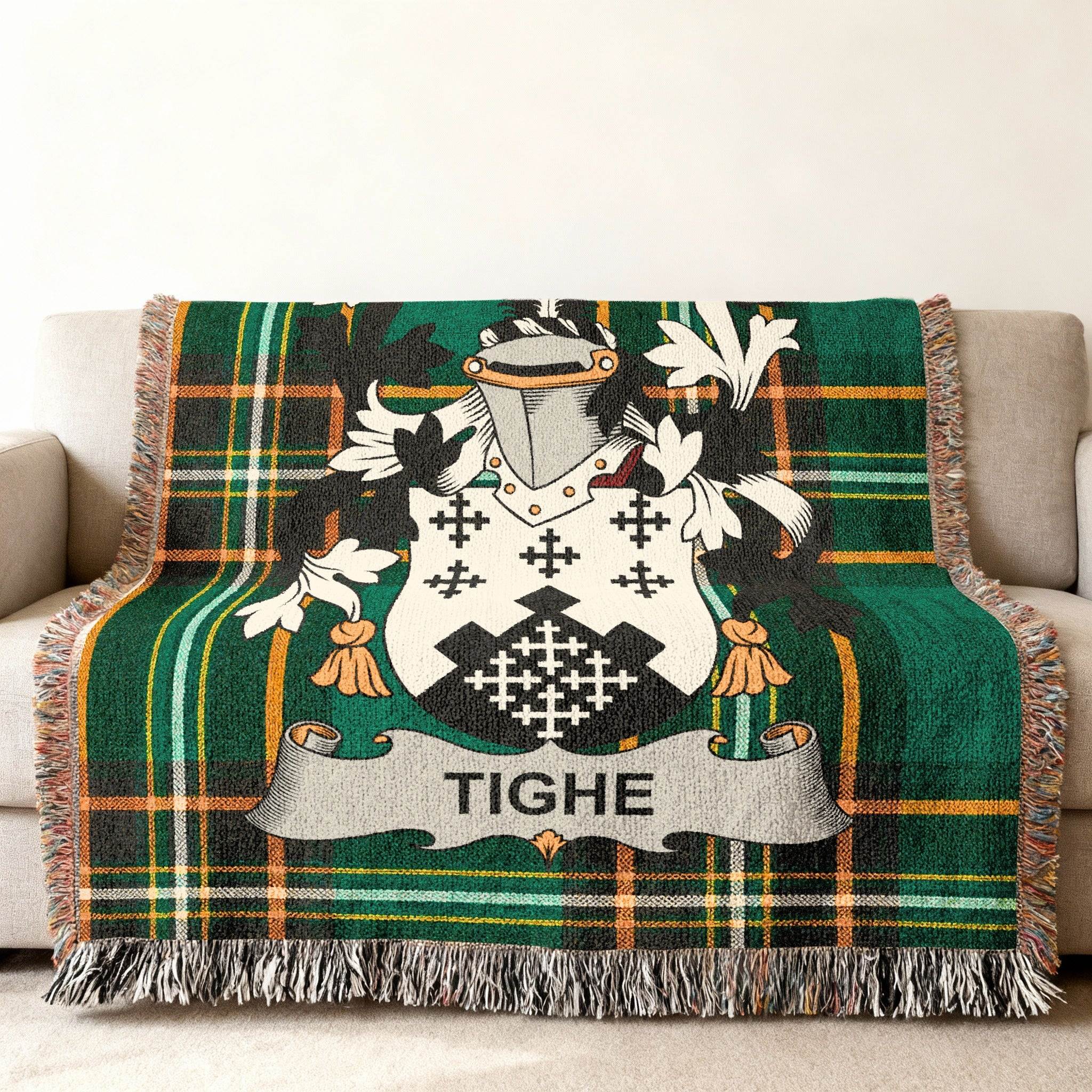 Tighe family crest on a green tartan woven blanket with fringe.