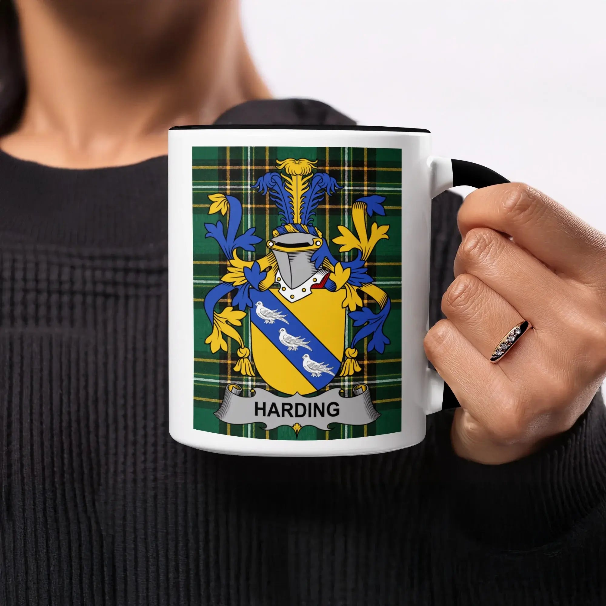 Coat of arms with "HARDING" on a white mug held by a person.