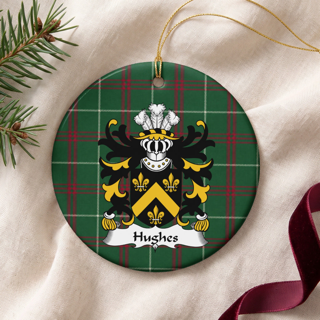 Hughes Style 1 ornament on cream fabric with gold string, evergreen and burgundy ribbon; a gold chevron and three gold fleurs-de-lis on a black shield on Welsh national tartan.