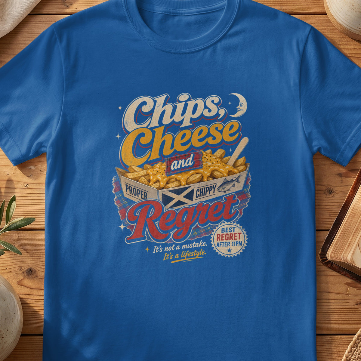 Blue t-shirt graphic with "Chips, Cheese and Regret" text over fries.