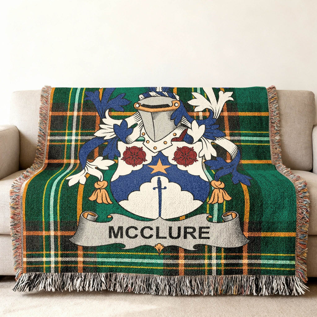 McClure family crest on a green tartan plaid throw blanket with fringe.