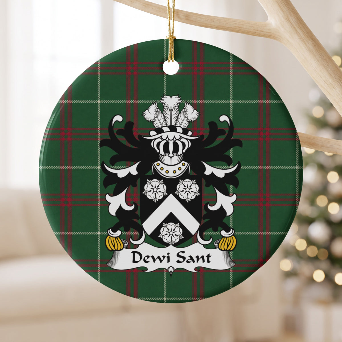 Dewi Sant ornament hanging from a pale wooden branch; a white chevron and three white roses on a black shield on Welsh national tartan.