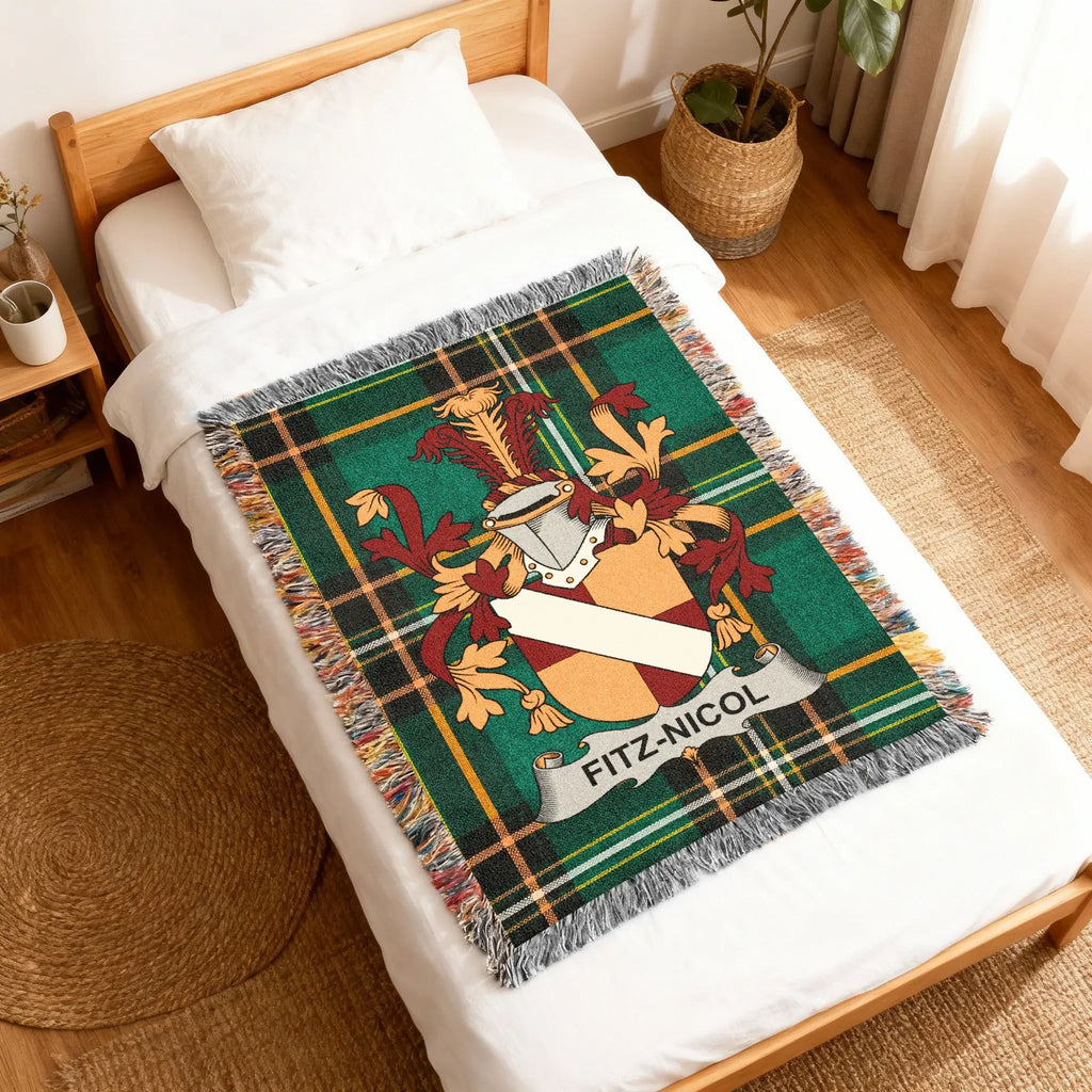 Woven blanket with Fitz-Nicol family crest on a bed.
