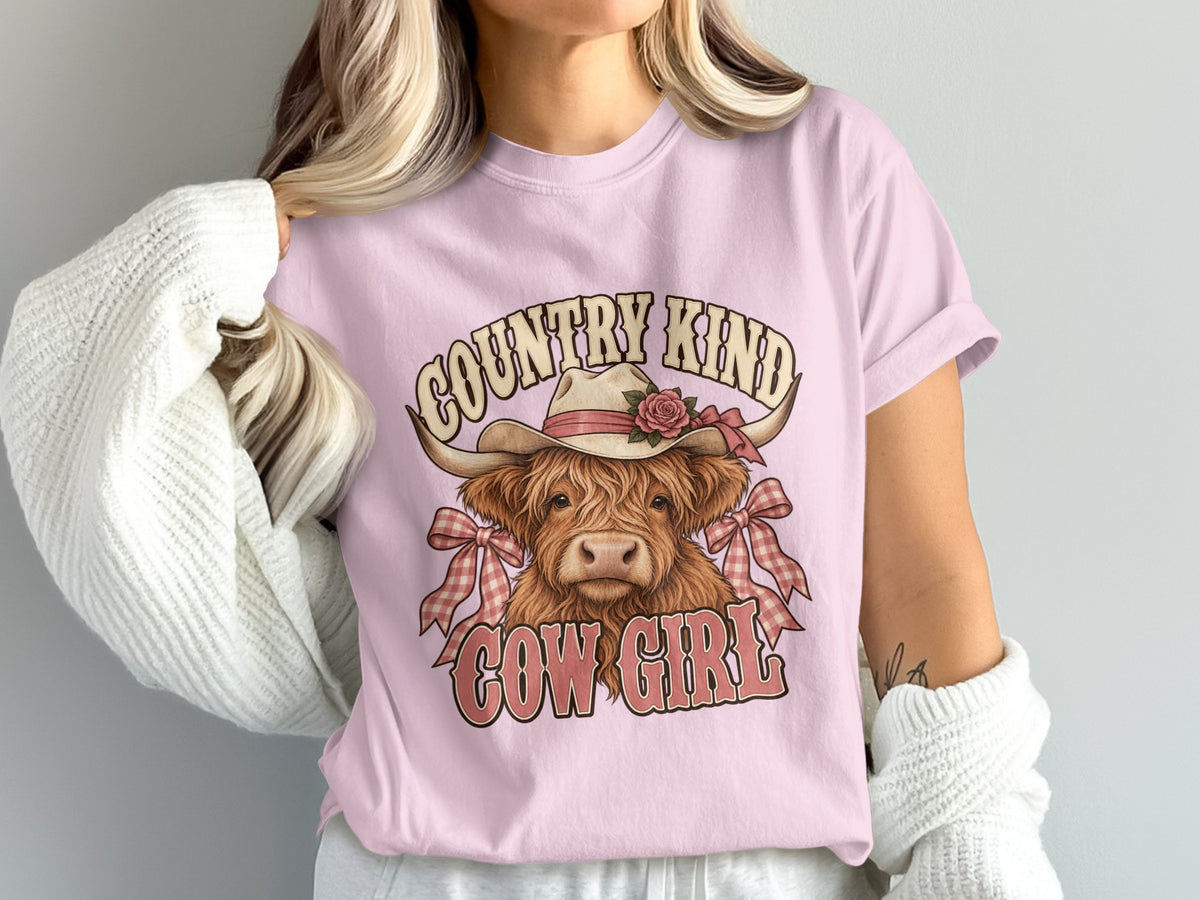 Model wearing the Country Kind Cow Girl Highland cow Comfort Colors T-shirt in Blossom