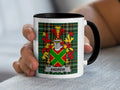 White mug with black rim featuring a Scottish tartan pattern and the surname Andrew.