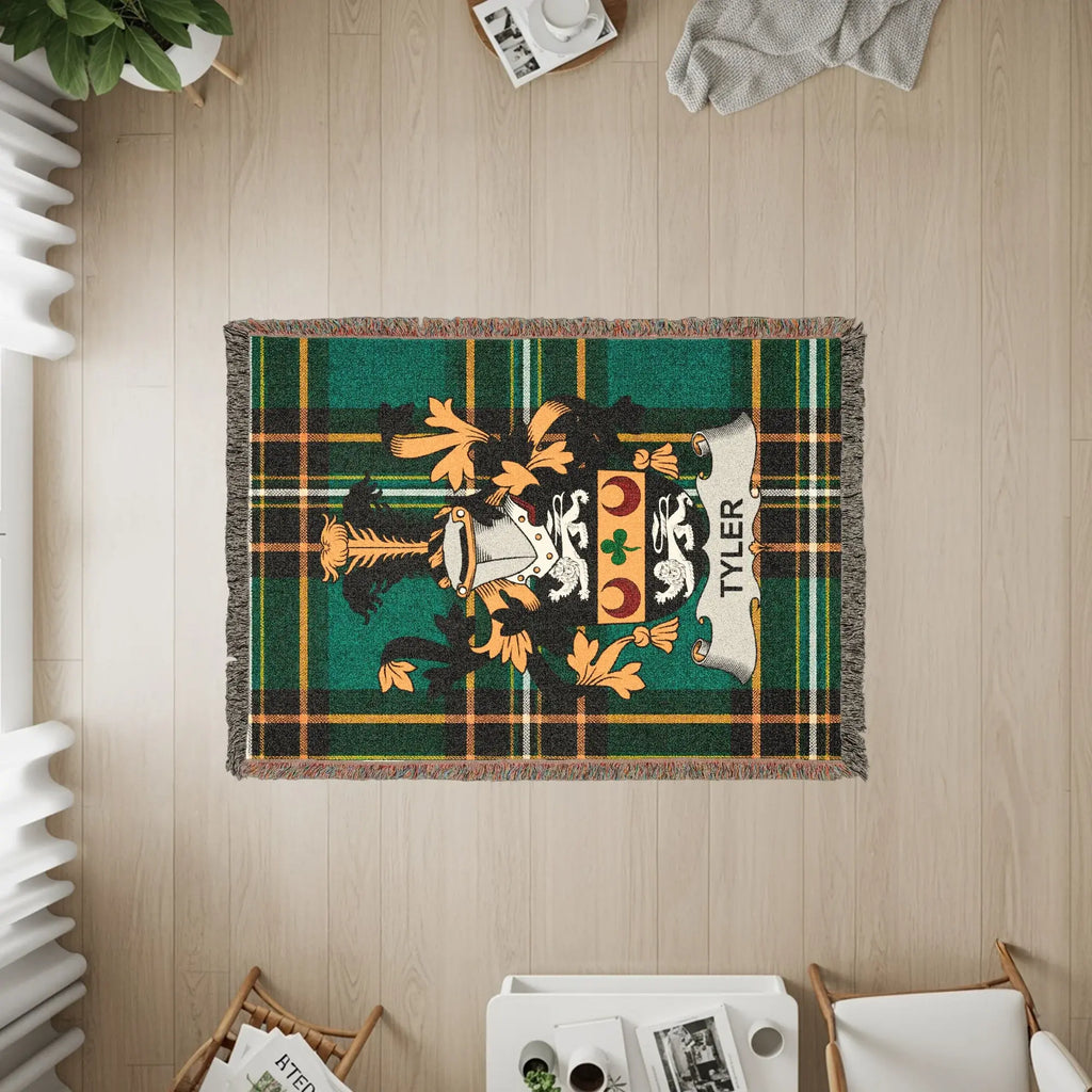 Woven throw blanket with a green plaid background and the Tyler family crest.