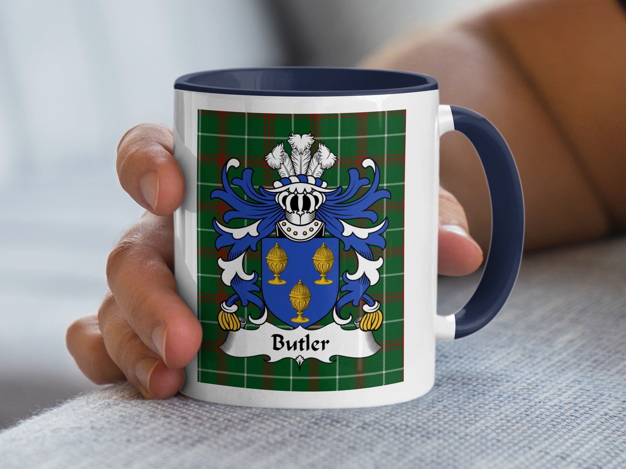 White mug with navy handle featuring Butler family crest on a green tartan background.