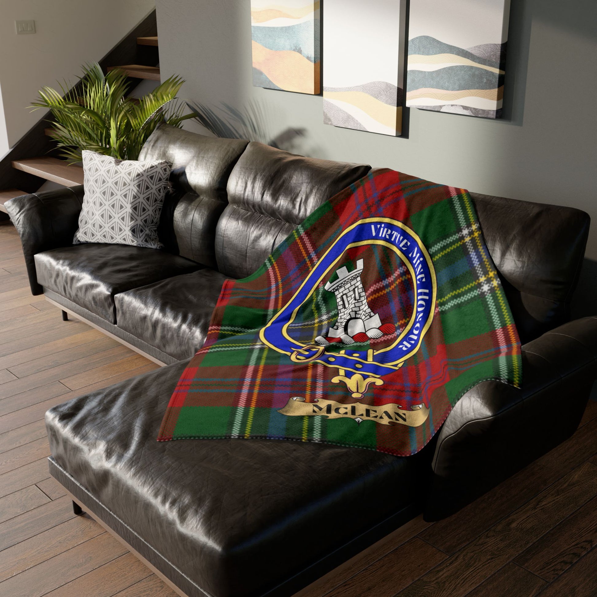McLean tartan plaid blanket with clan crest draped on a leather sofa.