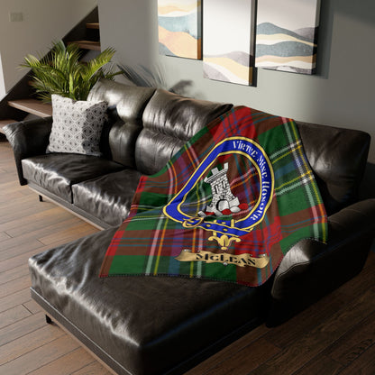 McLean tartan plaid blanket with clan crest draped on a leather sofa.