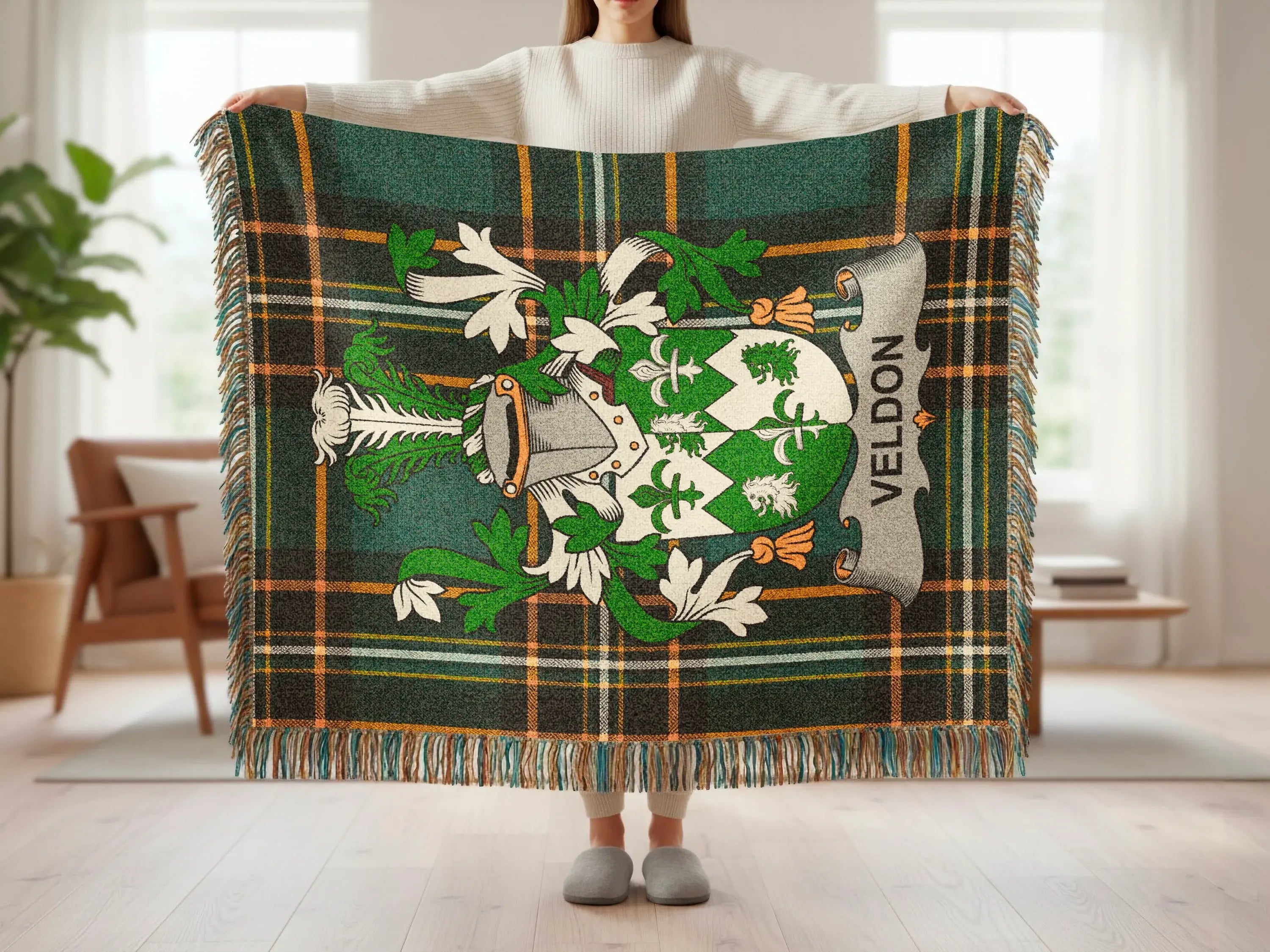 Tartan blanket with family crest featuring shield, helmet, and "Veldon" text.
