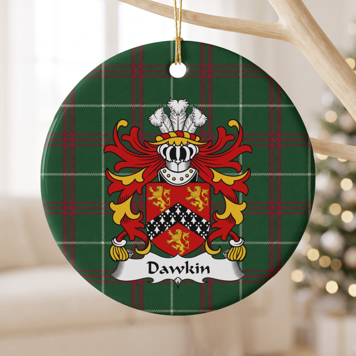Dawkin ornament hanging from a pale wooden branch; three gold lions around a black chevron with white ermine-style markings on red on Welsh national tartan.