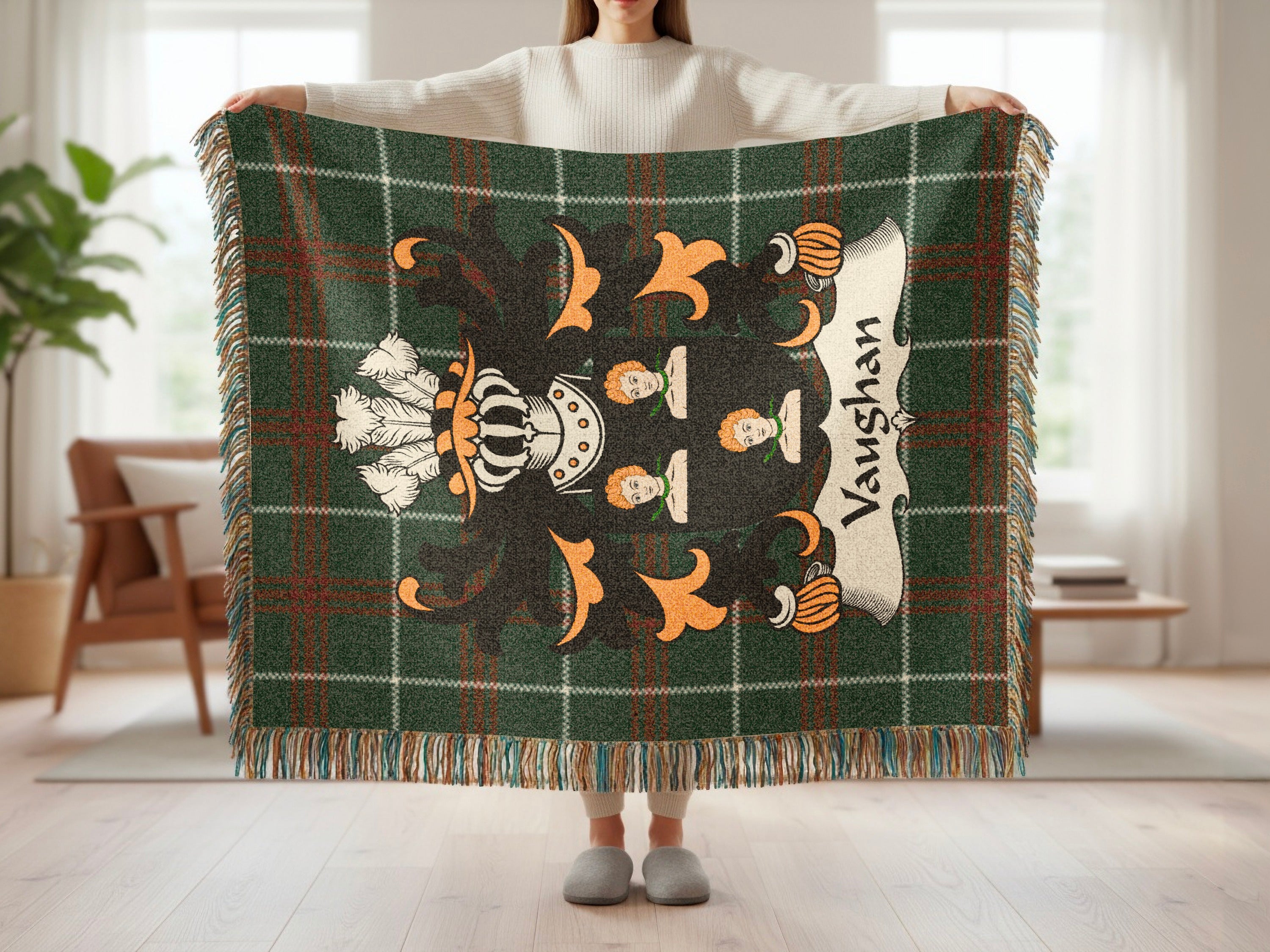 Green tartan throw blanket with a family crest featuring lions and a crown.