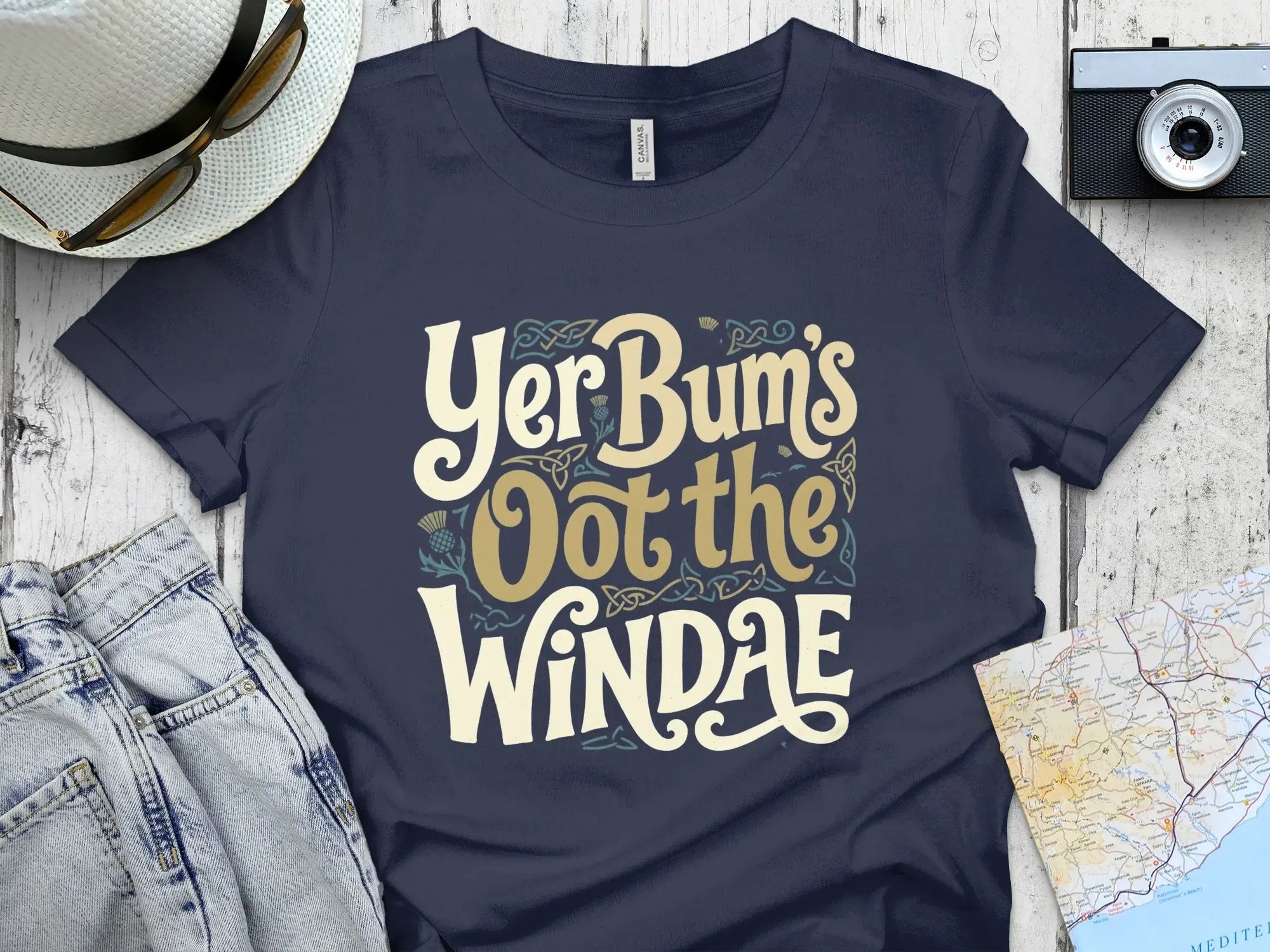 Dark blue t-shirt with "Yer Bum's Oot the WINDAE" text in decorative font.