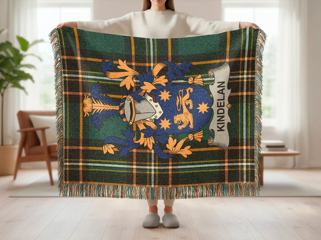 Tartan blanket with Kindelan crest and fringe held by person.