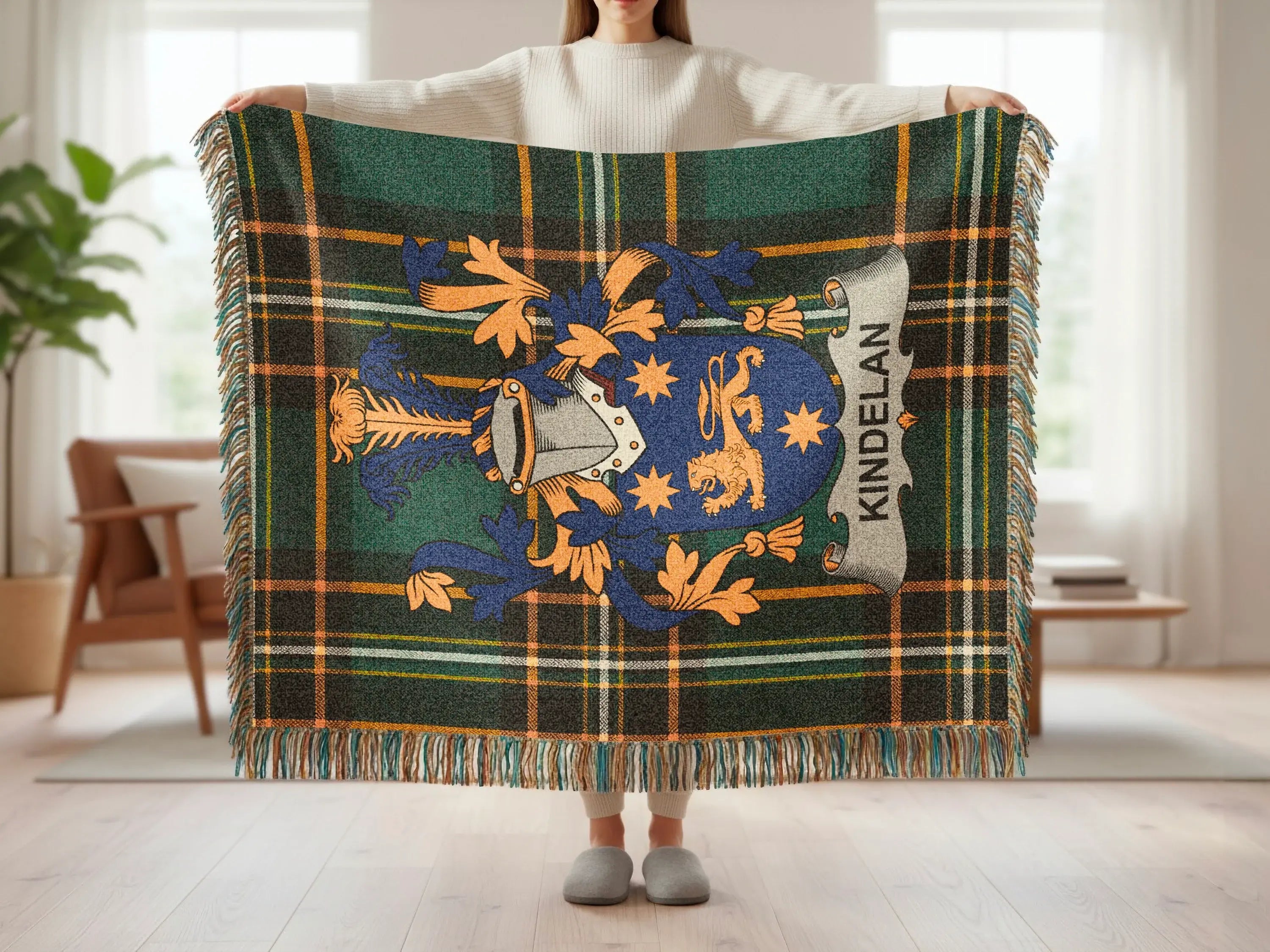 Tartan blanket with Kindelan crest and fringe held by person.