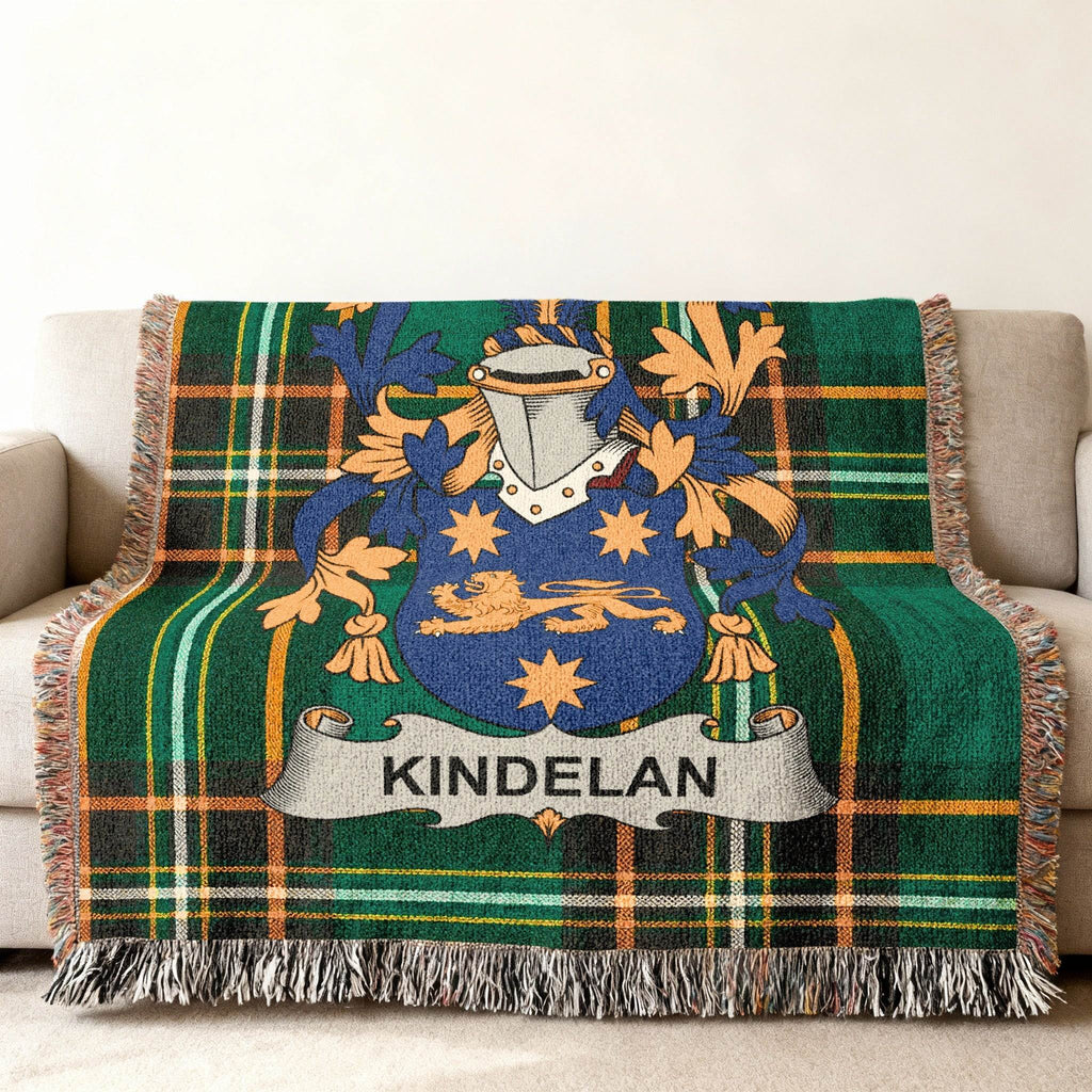 Green plaid throw blanket featuring a blue lion crest with the name "Kindelan" on a banner.